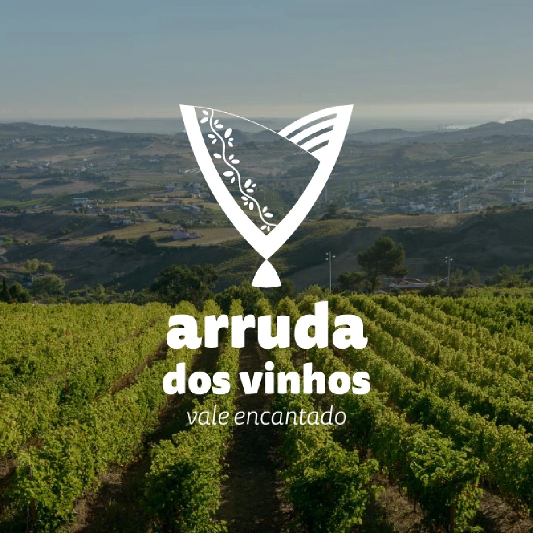 Paisagem de vinhas em Arruda dos Vinhos, Portugal, com o logótipo "Vale Encantado" em destaque