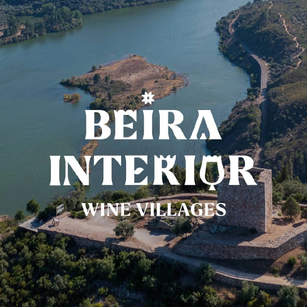 Vista aérea de uma paisagem histórica e rio na região da Beira Interior, com a marca "Beira Interior Wine Villages".