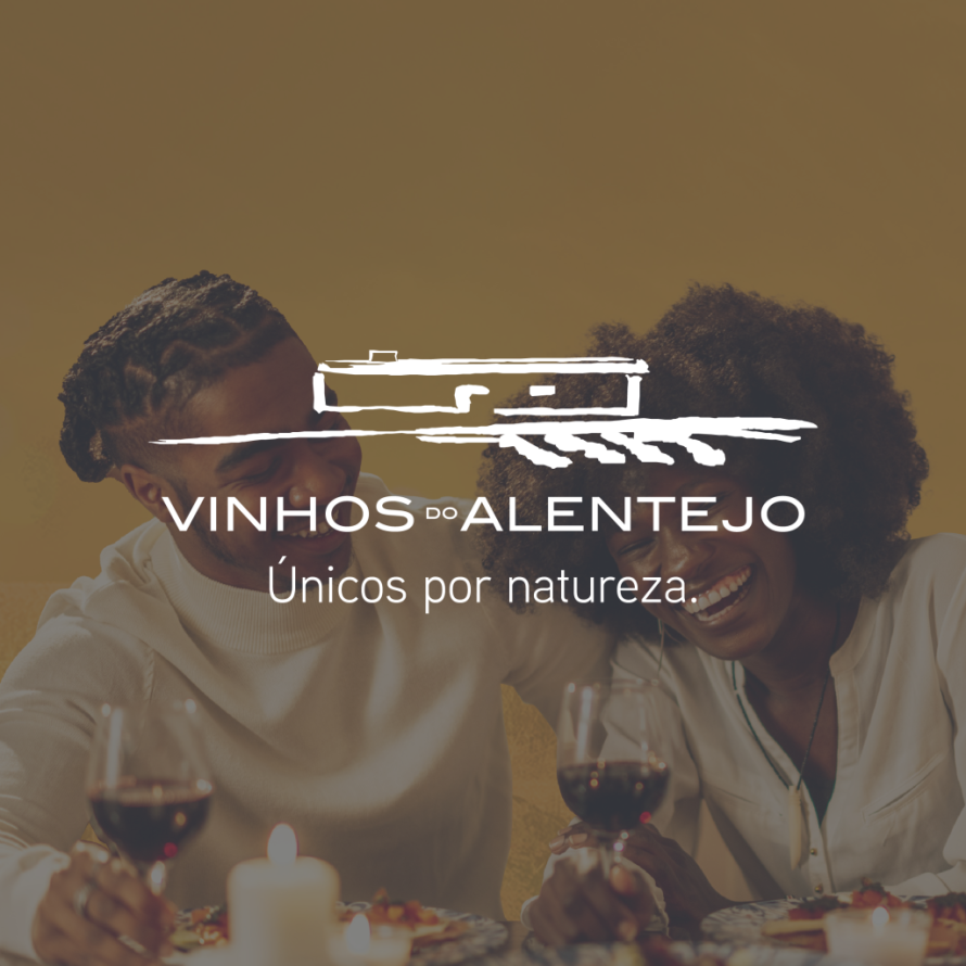 Casal a sorrir com vinho numa mesa com velas, sob o logótipo "Vinhos do Alentejo".